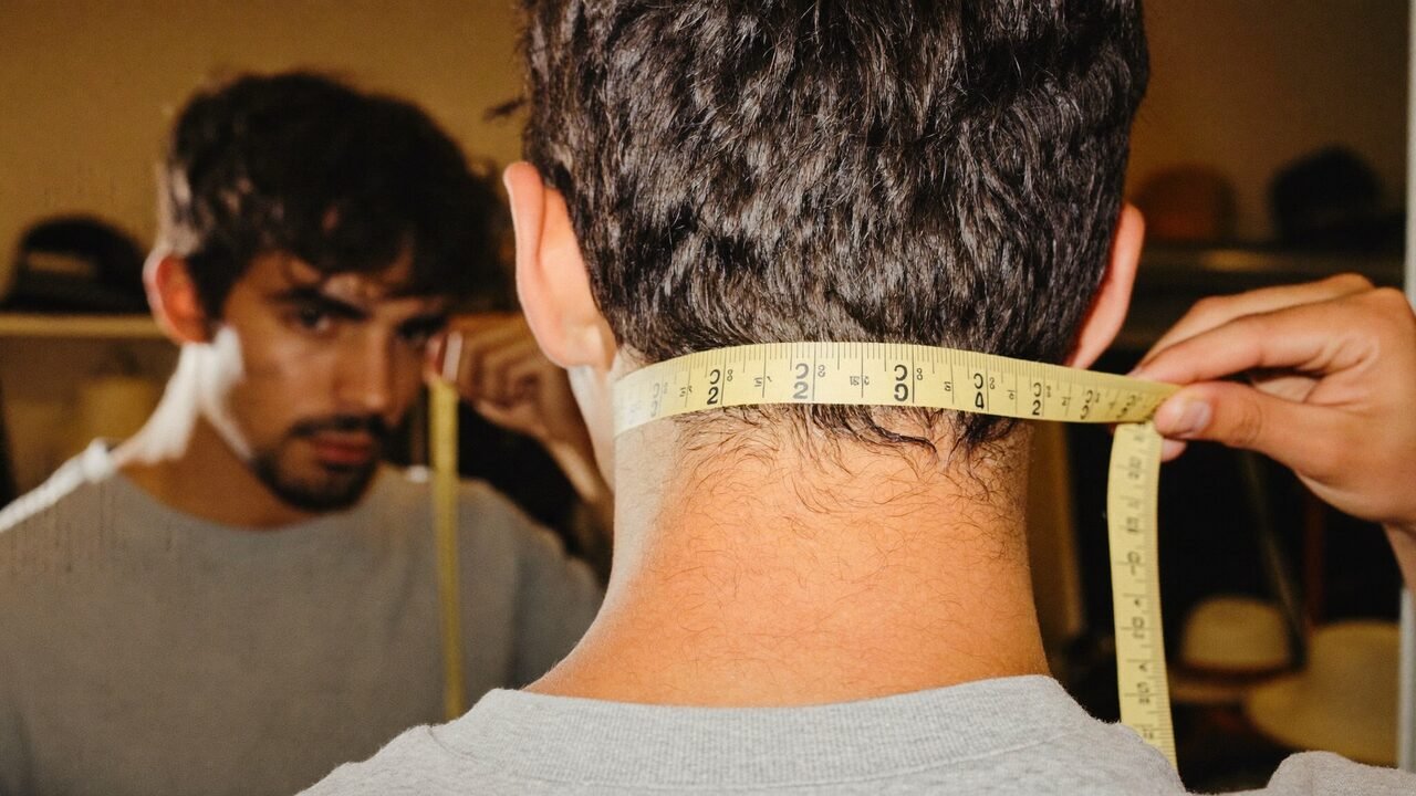 Homme mesurant son tour de tête avec un mètre ruban